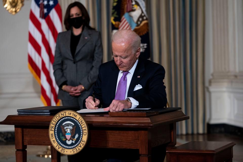 Vice President Kamala Harris looks on as President Joe Biden signs executives orders related to his racial equity agenda in the State Dining Room of the White House on Jan. 26, 2021.