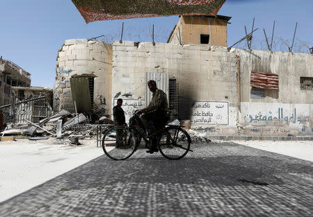 A man rides on a bicycle at the city of Douma in Damascus, Syria, April 20, 2018. REUTERS/Omar Sanadiki