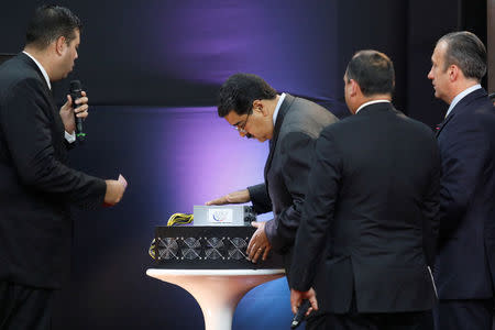 Venezuela's President Nicolas Maduro (C) examines a cryptocurrency mining computer during the event launching the new Venezuelan cryptocurrency "Petro" in Caracas, Venezuela February 20, 2018. REUTERS/Marco Bello