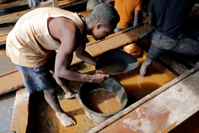 FILE PHOTO: An artisanal miner pans for gold in alluvial sediment over a plastic bucket at the unlicensed mining site of Nsuaem Top in Ghana