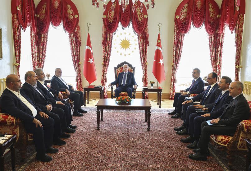 In this photo released by the Turkish Presidency, Turkey's President Recep Tayyip Erdogan, center, and ministers of his government, right, meet with Hamas delegation.