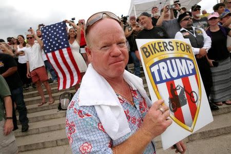 A man carries a sign for Republican U.S. presidential candidate Donald Trump at the Rolling Thunder motorcycle rally to highlight POW-MIA issues on Memorial Day weekend in Washington, U.S. May 29, 2016. REUTERS/Jonathan Ernst