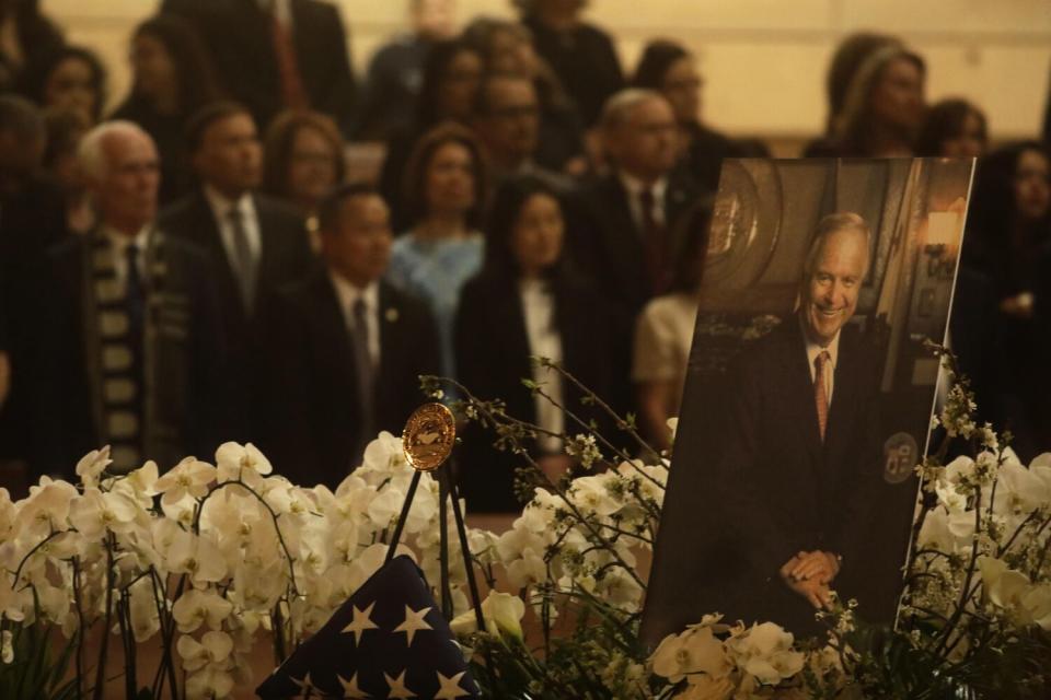 Present and past Los Angeles politicians stand behind a portrait of Mayor Richard Riordan during a memorial Mass
