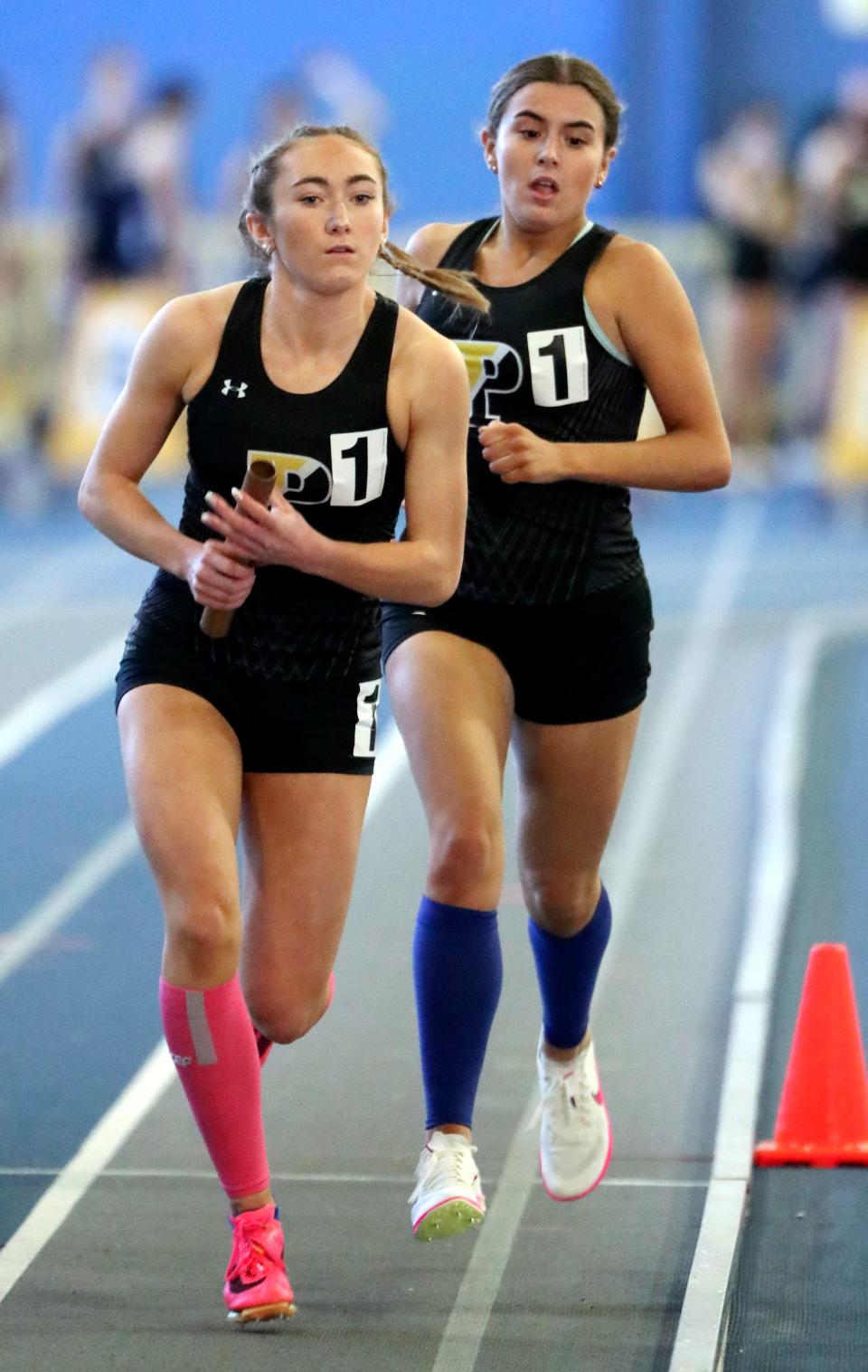 Padua's Molly Flanagan takes the baton from Kelsey Wolff as their team wins the 4x800 meter relay during the DIAA indoor track and field championships at the Prince George's Sports and Learning Complex in Landover, Md., Saturday, Feb. 3, 2023.