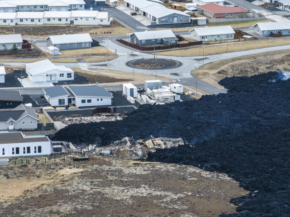 An areal view of the lava flow front in the town of Grindavik, Iceland, Monday, Jan. 15, 2024. Iceland's president says the country is battling "tremendous forces of nature" after molten lava from a volcano consumed several houses in the evacuated town of Grindavik. (AP Photo/ Marco Di Marco)