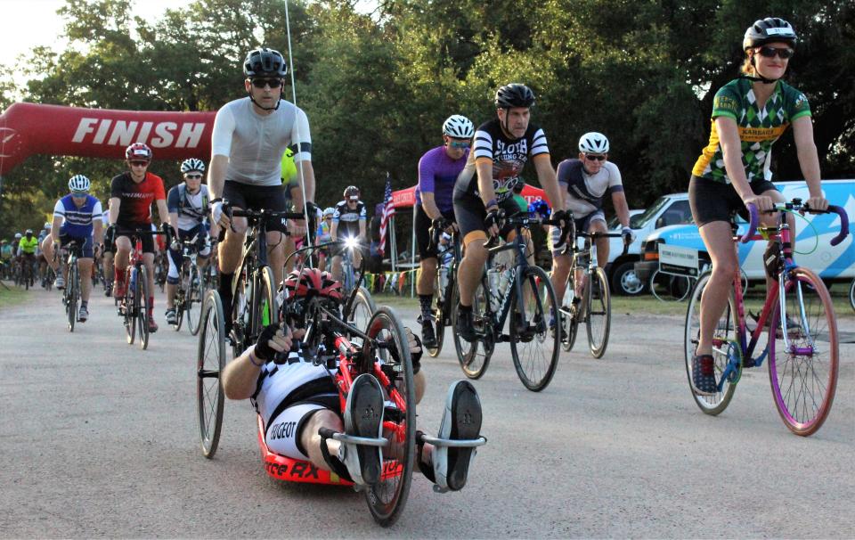 Cyclists roll out, some almost on their backs and some with lights on, at the start of the 100K ride at the 2021 Tour de Gap in Buffalo Gap.