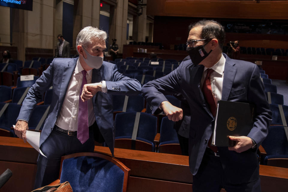 Federal Reserve Chairman Jerome Powell (left) and Treasury Secretary Steven Mnuchin bump elbows at the conclusion of a June 30 House Committee on Financial Services hearing on the pandemic response. (Photo: TASOS KATOPODIS/pool/AFP via Getty Images)