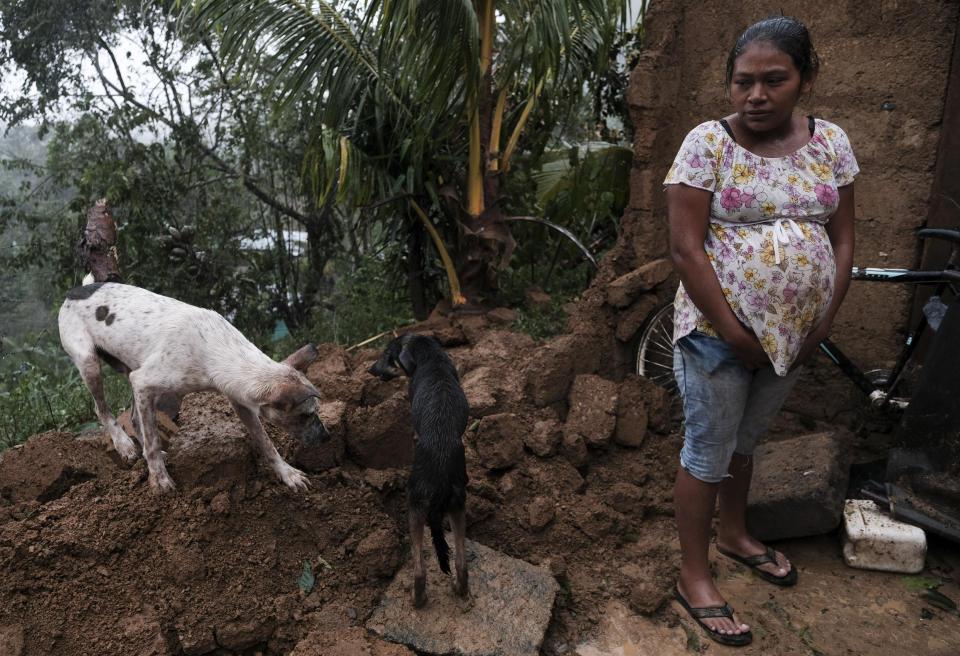 A woman stands by the fallen wall of her house after the passage of Hurricane Iota in Siuna, Nicaragua, Tuesday, Nov. 17, 2020. Hurricane Iota tore across Nicaragua on Tuesday, hours after roaring ashore as a Category 4 storm along almost exactly the same stretch of the Caribbean coast that was recently devastated by an equally powerful hurricane. (AP Photo/Carlos Herrera)