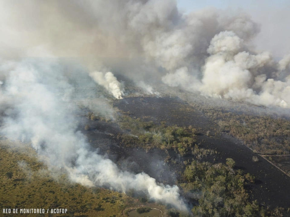 In this undated photo provided by the Association of Forest Communities of Peten on June 2020, fire and smoke envelop a part of the Laguna Del Tigre National Park in northern Guatemala. In 2020, the region has experienced a worrisome uptick in fires set illegally to clear land, while government resources to control flames have been diverted to manage the COVID-19 pandemic. (Alvaro Ba/ACOFOP via AP)