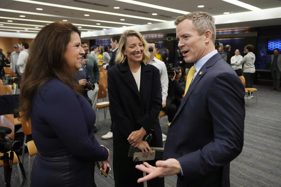 University of Michigan Board of Regents member Sarah Hubbard, left, talks with new NCAA college basketball head coach Dusty May and his wife Anna May after a news conference, Tuesday, March 26, 2024, in Ann Arbor, Mich. (AP Photo/Carlos Osorio)