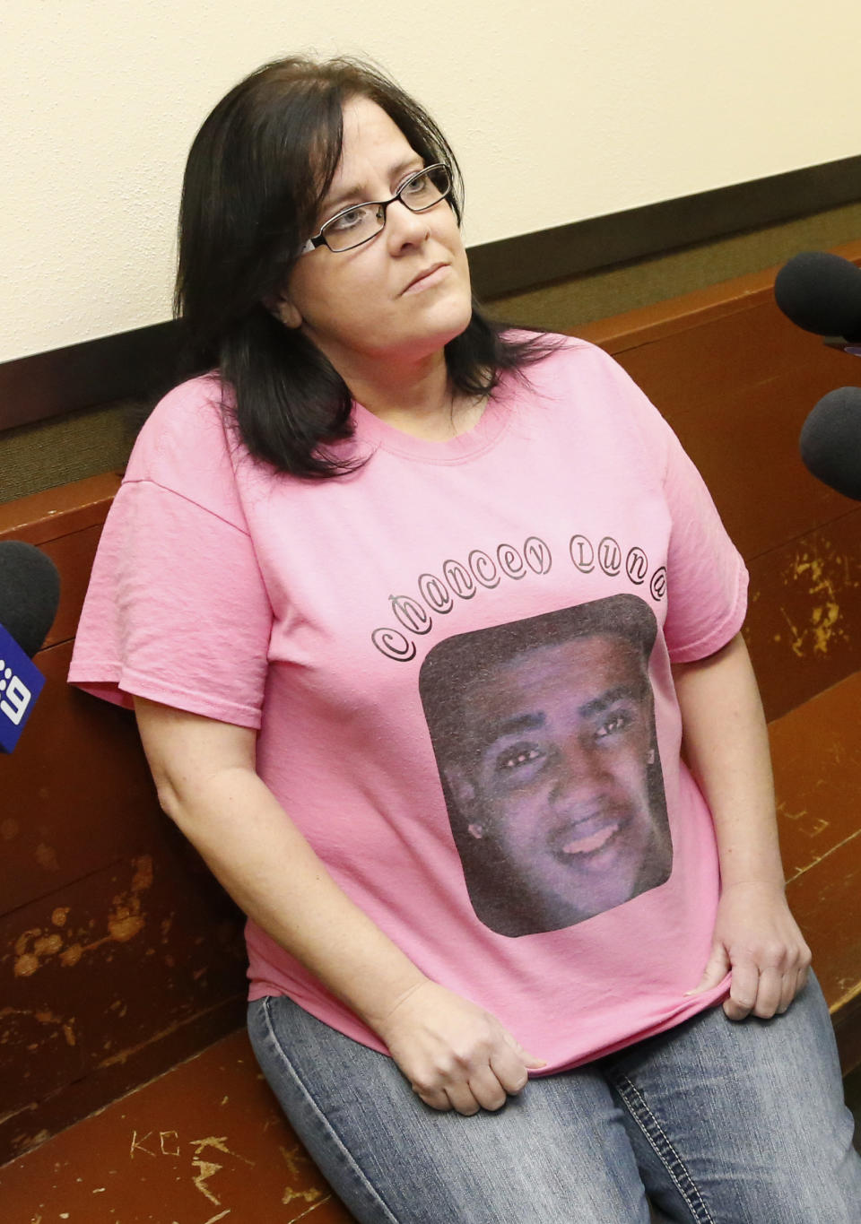 Jennifer Luna, the mother of murder suspect Chancey Luna, shows the shirt she is wearing with a photo of her son to the media before a hearing in Duncan, Okla, Wednesday, March 12, 2014. Chancey Luna is charged in the murder of Australian Christopher Lane. (AP Photo/Sue Ogrocki)