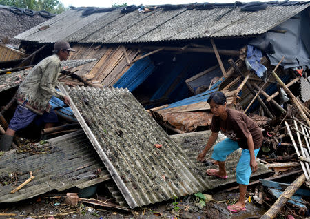 Residents collect debris from their collapsed house after it was hit by a tsunami at Panimbang district in Pandeglang, Banten province, Indonesia, December 23, 2018, in this photo taken by Antara Foto. Antara Foto/Muhammad Bagus Khoirunas/ via REUTERS