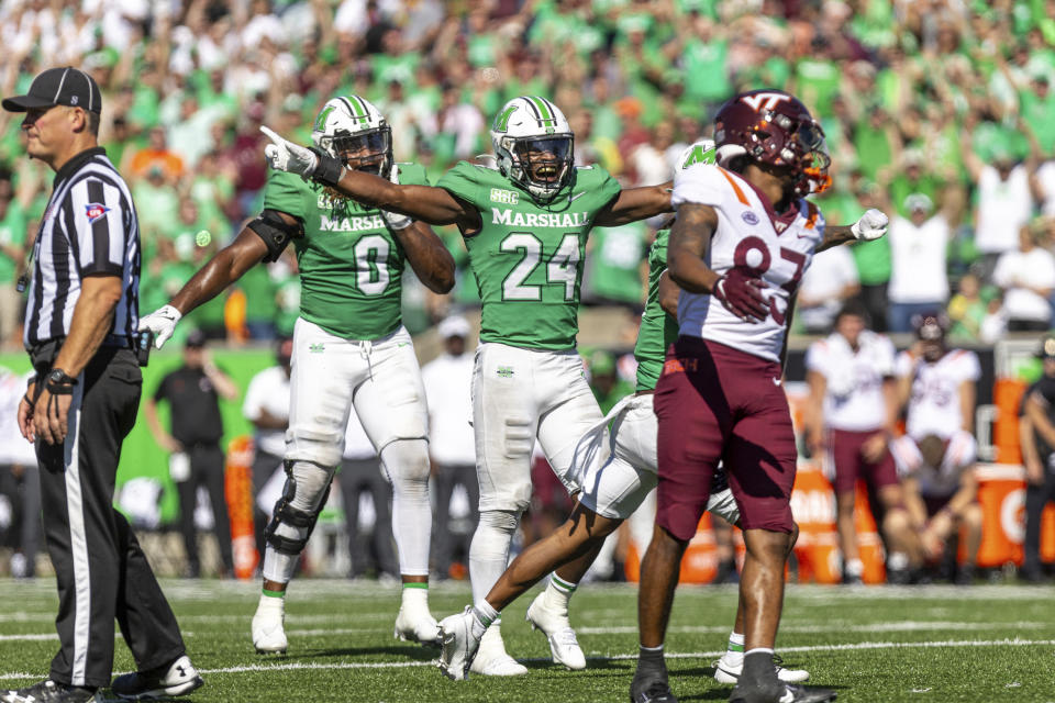 Marshall's Eli Neal (24) and Sam Burton (0) celebrate a fourth down stop on Virginia Tech during an NCAA college football game, Saturday, Sept. 23, 2023, at Joan C. Edwards Stadium in Huntington, W.Va. (Sholten Singer/The Herald-Dispatch via AP)
