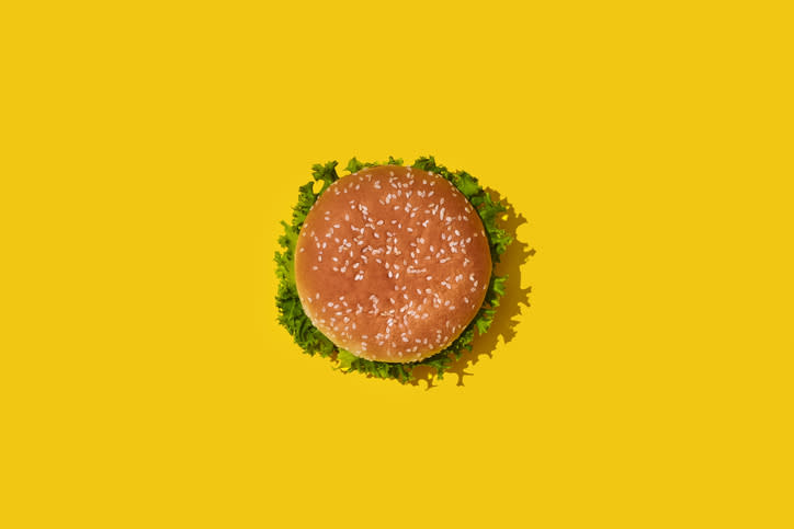 A burger on a bright yellow surface