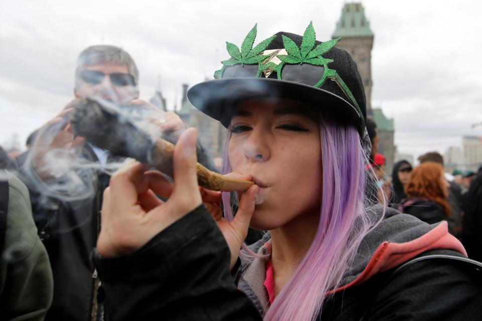 A woman smokes marijuana during the annual 4/20 marijuana rally on Parliament Hill in Ottawa, Ontario, Canada, April 20, 2017. (Reuters)