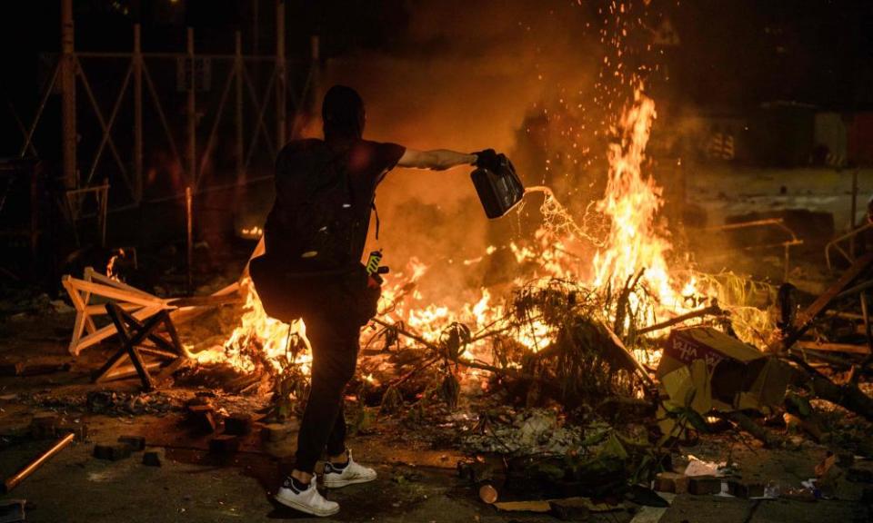 A protester pours petrol onto a burning barricade at the Chinese University of Hong Kong on Tuesday night.