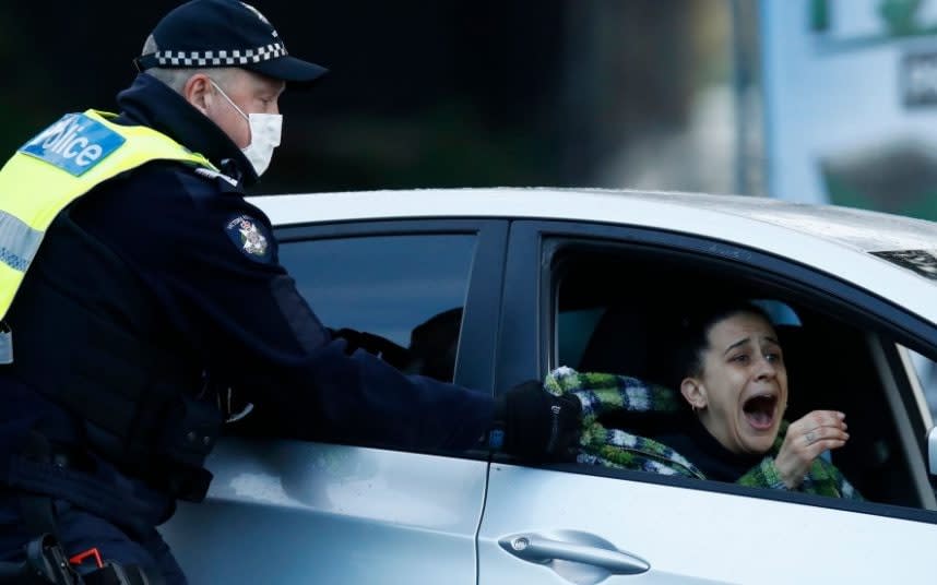 A police officer grabs a woman's jacket as she tries to leave a tower block - DANIEL POCKETT/EPA-EFE/Shutterstock 