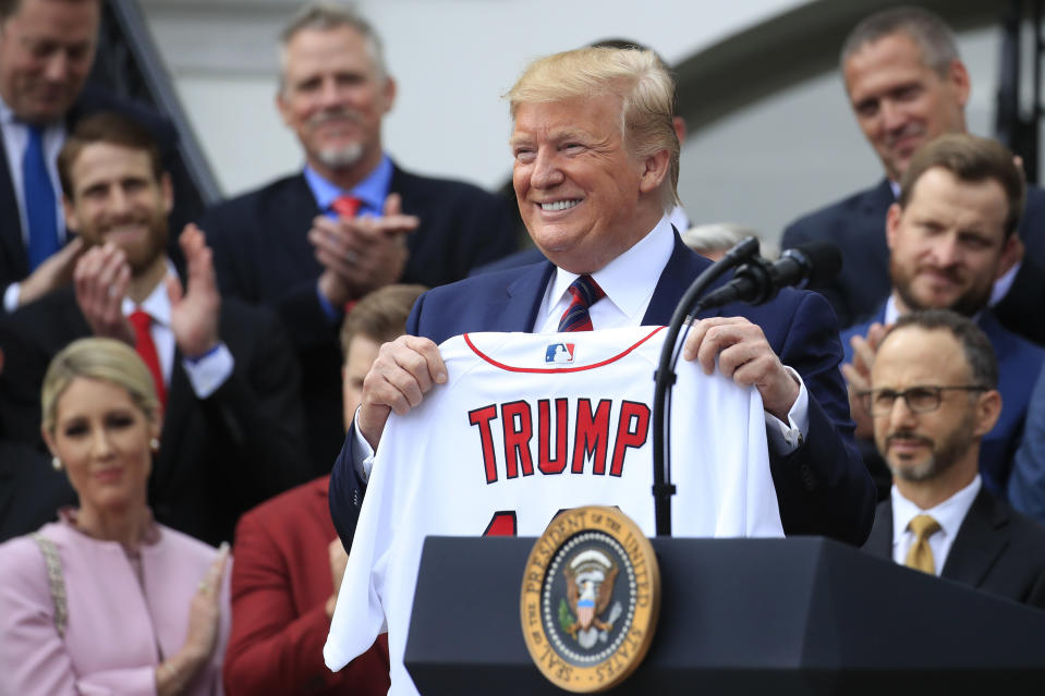 President Donald Trump shows off a Red Sox jersey presented to him during a ceremony welcoming the Boston Red Sox the 2018 World Series baseball champions to the White House.