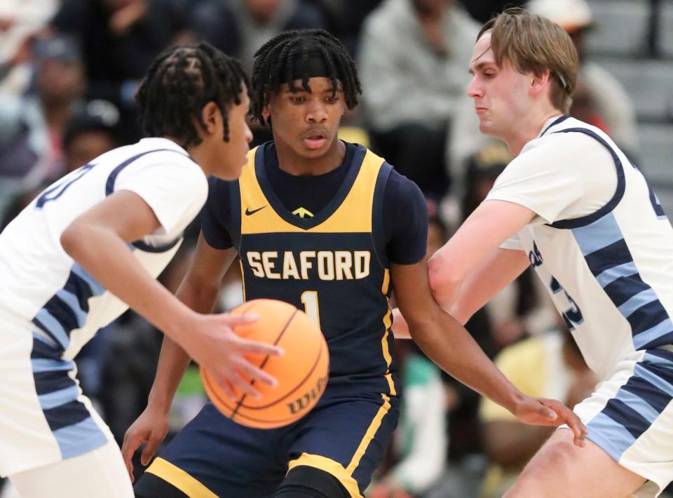 Seaford's Vincent Evans III works on defense between Lake Forest's Seth Young (left) and Adam Mudri in Seaford's 65-62 win at Lake Forest High, Tuesday, Jan. 30, 2024.