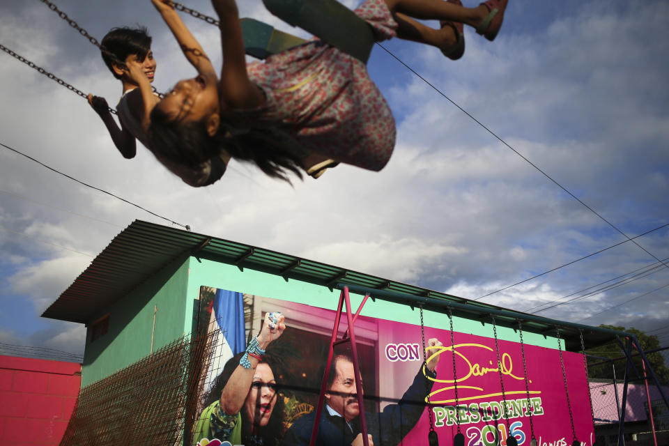 FILE - In this Nov. 4, 2016 file photo, children swing in a park next to an election billboard for President Daniel Ortega and his running mate, his wife, Rosario Murillo in Managua, Nicaragua. In June 2021, amid a weekslong clampdown to obliterate nearly every hint of opposition, Ortega ordered the arrest of Hugo Torres, a revered guerrilla in the fight against right-wing dictator Anastasio Somoza. In 1974, Torres had taken a group of top officials hostage, then traded them for the release of imprisoned comrades, among them, Daniel Ortega. (AP Photo/Esteban Felix, File)