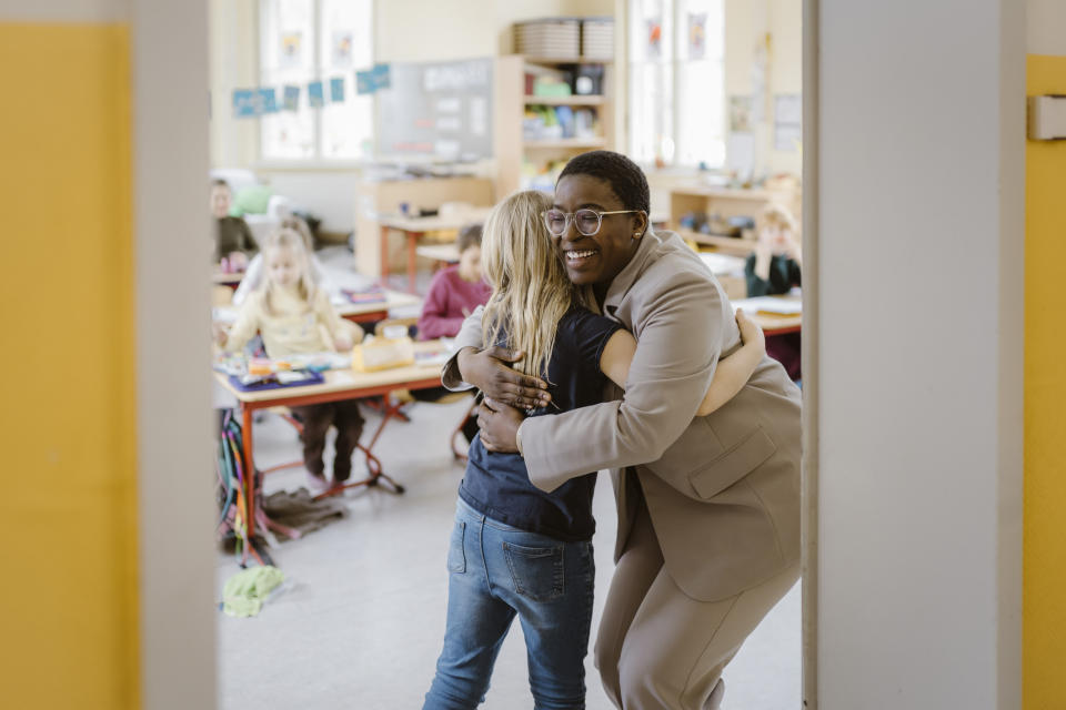 A teacher hugging a student