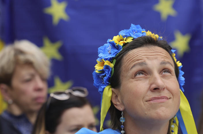 A protestor wears a flower headband in the Ukraine colors as she participates in a demonstration in support of Ukraine outside of an EU summit in Brussels, Thursday, June 23, 2022. European Union leaders are expected to approve Thursday a proposal to grant Ukraine a EU candidate status, a first step on the long toward membership. (AP Photo/Olivier Matthys)