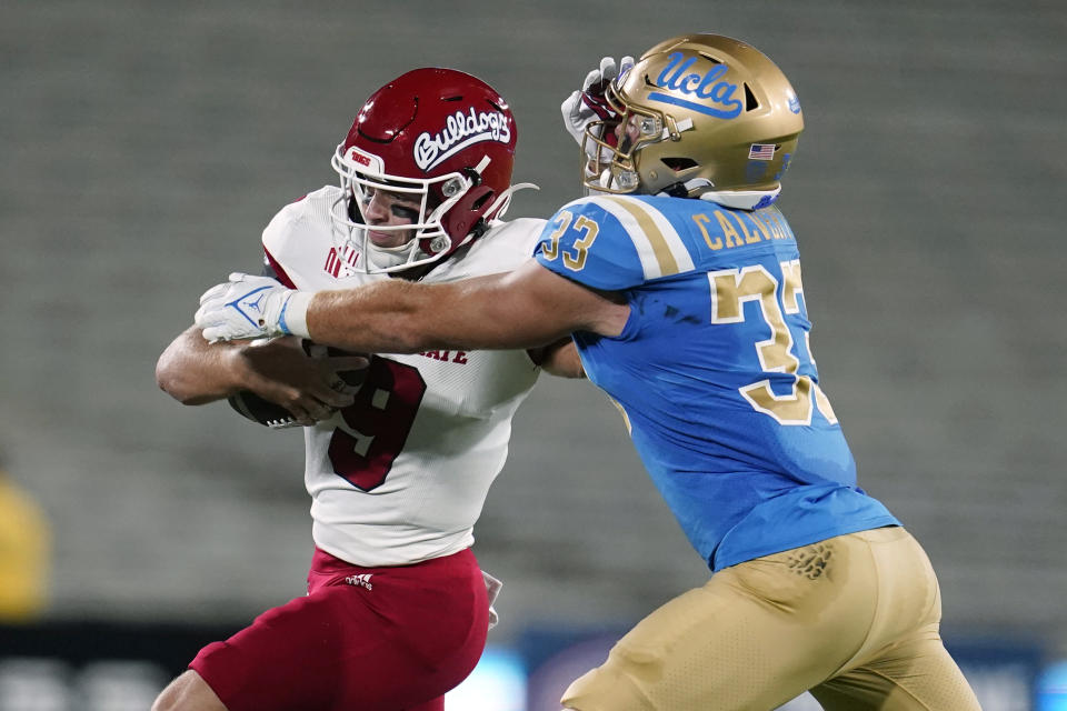 Fresno State quarterback Jake Haener, left, stiff-arms UCLA linebacker Bo Calvert (33) during the first half of an NCAA college football game Saturday, Sept. 18, 2021, in Pasadena, Calif. (AP Photo/Marcio Jose Sanchez)