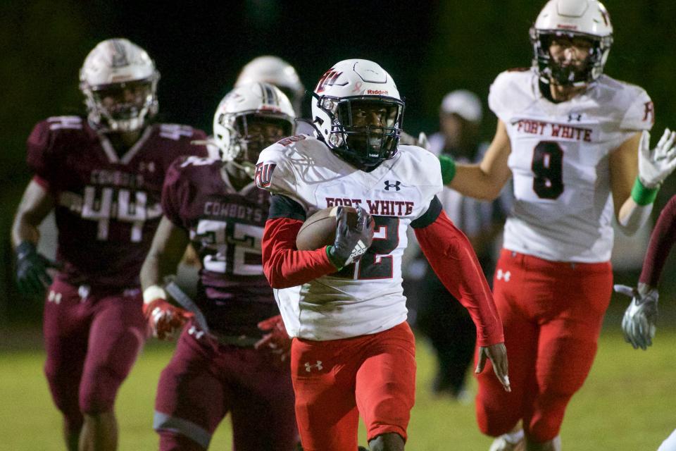 Fort White junior Najeeb Smith (12) rushes the ball against Madison County in 2022.