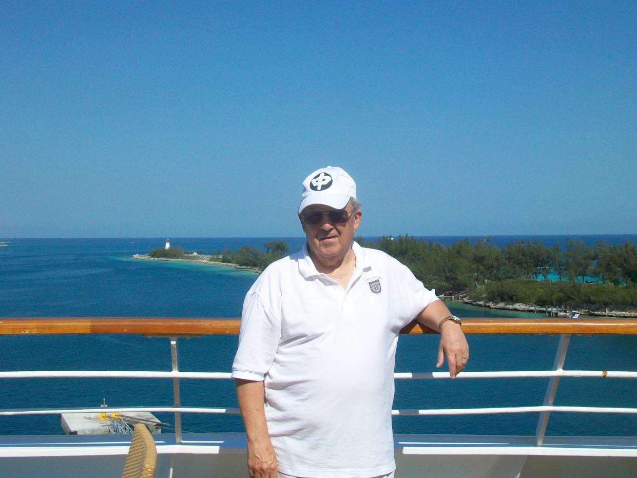 robert l willett posing for a photo on the deck of a cruise ship in front of blu skies