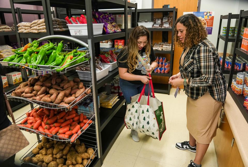 Social worker Kierten Hazelwood, right, helps Yaquelin Cornejo select food from the Creedmoor Elementary School pantry Friday. Because of the pantry, Cornejo won't always have to make a round trip of more than 40 minutes, partly on a toll road, to get groceries.