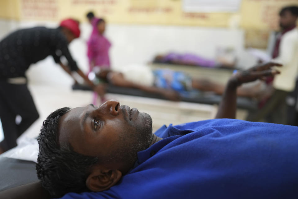 A person suffering from heat related ailment lies on a stretcher at the foyer of an overcrowded government district hospital in Ballia, Uttar Pradesh state, India, Monday, June 19, 2023. Several people have died in two of India's most populous states in recent days amid a searing heat wave, as hospitals find themselves overwhelmed with patients. More than hundred people in the Uttar Pradesh state, and dozens in neighboring Bihar state have died due to heat-related illness. (AP Photo/Rajesh Kumar Singh)