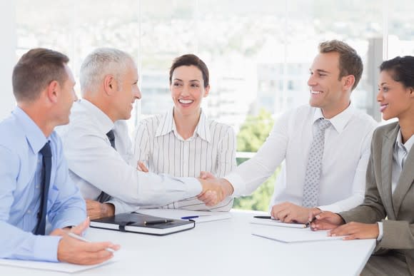Business people shaking hands and smiling