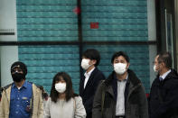 People stand an electronic stock board showing Japan's Nikkei 225 index at a securities firm in Tokyo Tuesday, Feb. 25, 2020. Shares are mostly lower in Asia on Tuesday after Wall Street suffered its worst session in two years, with the Dow Jones Industrial Average slumping more than 1,000 points on fears that a viral outbreak that began in China will weaken the world economy.(AP Photo/Eugene Hoshiko)