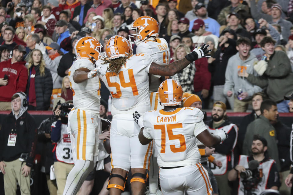 Tennessee wide receiver Bru McCoy (15), offensive lineman Gerald Mincey (54) and offensive lineman Jerome Carvin (75) celebrate with wide receiver Cedric Tillman (4) after his touchdown during the first half of an NCAA college football game against South Carolina on Saturday, Nov. 19, 2022, in Columbia, S.C. (AP Photo/Artie Walker Jr.)