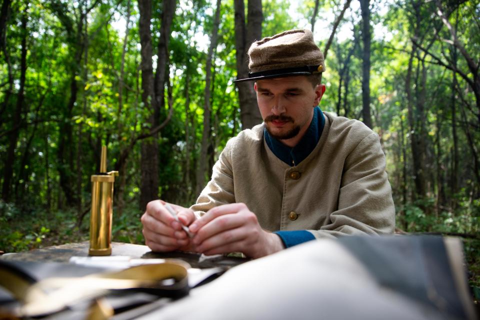 Alex Hardbarger fills cartridges with gunpowder Saturday, Sept. 17, 2022, in Holland. 