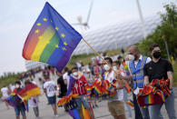 Football supporters are seen with LGBT pride flags outside of the stadium before the Euro 2020 soccer championship group F match between Germany and Hungary at the Allianz Arena in Munich, Germany,Wednesday, June 23, 2021. (AP Photo/Matthias Schrader)