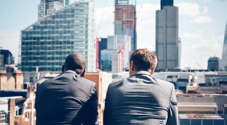 A pair of investors look out at a building under construction. A Natixis Investment Managers survey of 500 institutional investors around the world identified the sectors and classes expected to post the biggest gains in 2022.