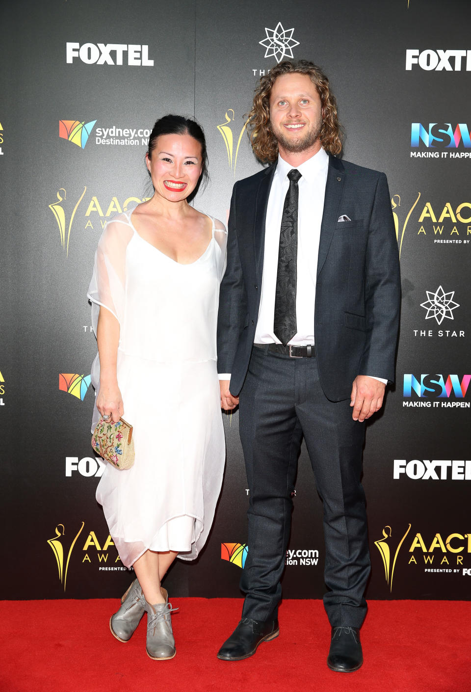 Poh Ling Yeow in a white midi dress and Jono Bennett in a dark suit arrive ahead of the 6th AACTA Awards Presented by Foxtel at The Star on December 7, 2016 in Sydney, Australia.