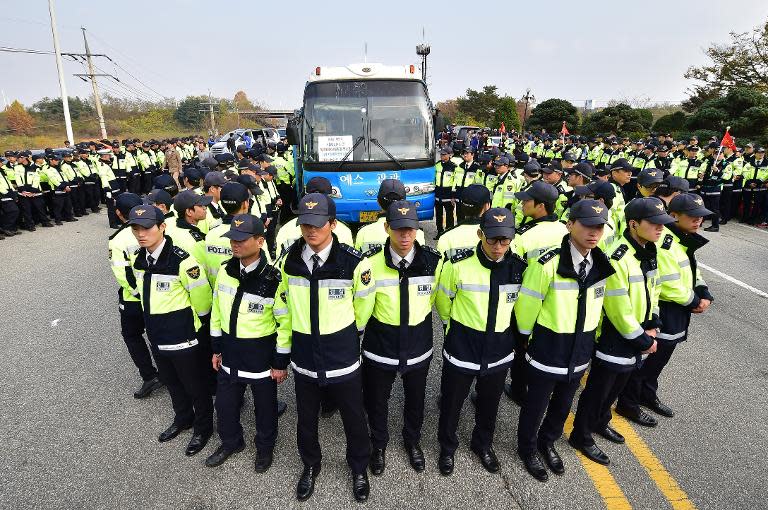 South Korean police surround a bus carrying activists after local residents hurled eggs at it near Imjingak peace park in the border city of Paju, on October 25, 2014