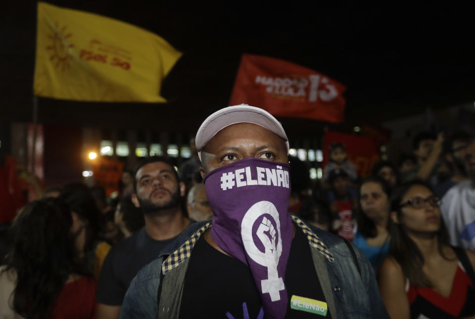 A man wears a scarf that reads in Portuguese "Not him", during a protest against Jair Bolsonaro, a far-right presidential candidate in Sao Paulo, Brazil, Wednesday, Oct. 10, 2018. Bolsonaro will face off with Workers Party candidate Fernando Haddad in an election runoff on Oct. 28. (AP Photo/Andre Penner)