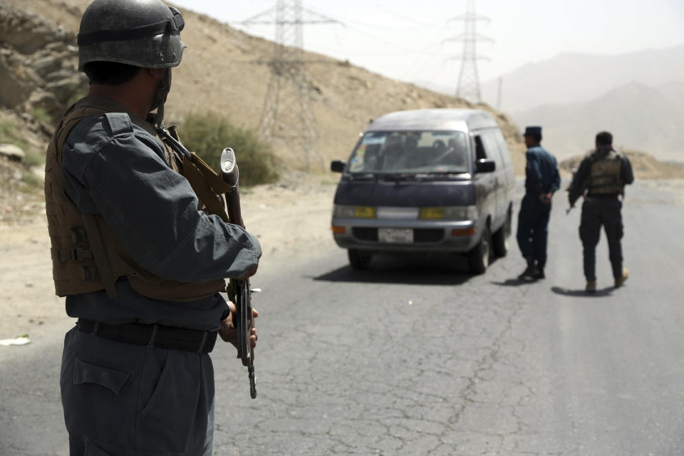 Afghan police officers search a vehicle at a checkpoint on the Ghazni highway, in Maidan Shar, west of Kabul, Afghanistan, Monday, Aug. 13, 2018. Afghan Defense Minister Gen. Tareq Shah Bahrami said Monday that about 100 policemen and soldiers as well as 20 civilians have been killed in past four days of battle in the eastern capital of Ghazni. (AP Photo/Rahmat Gul)