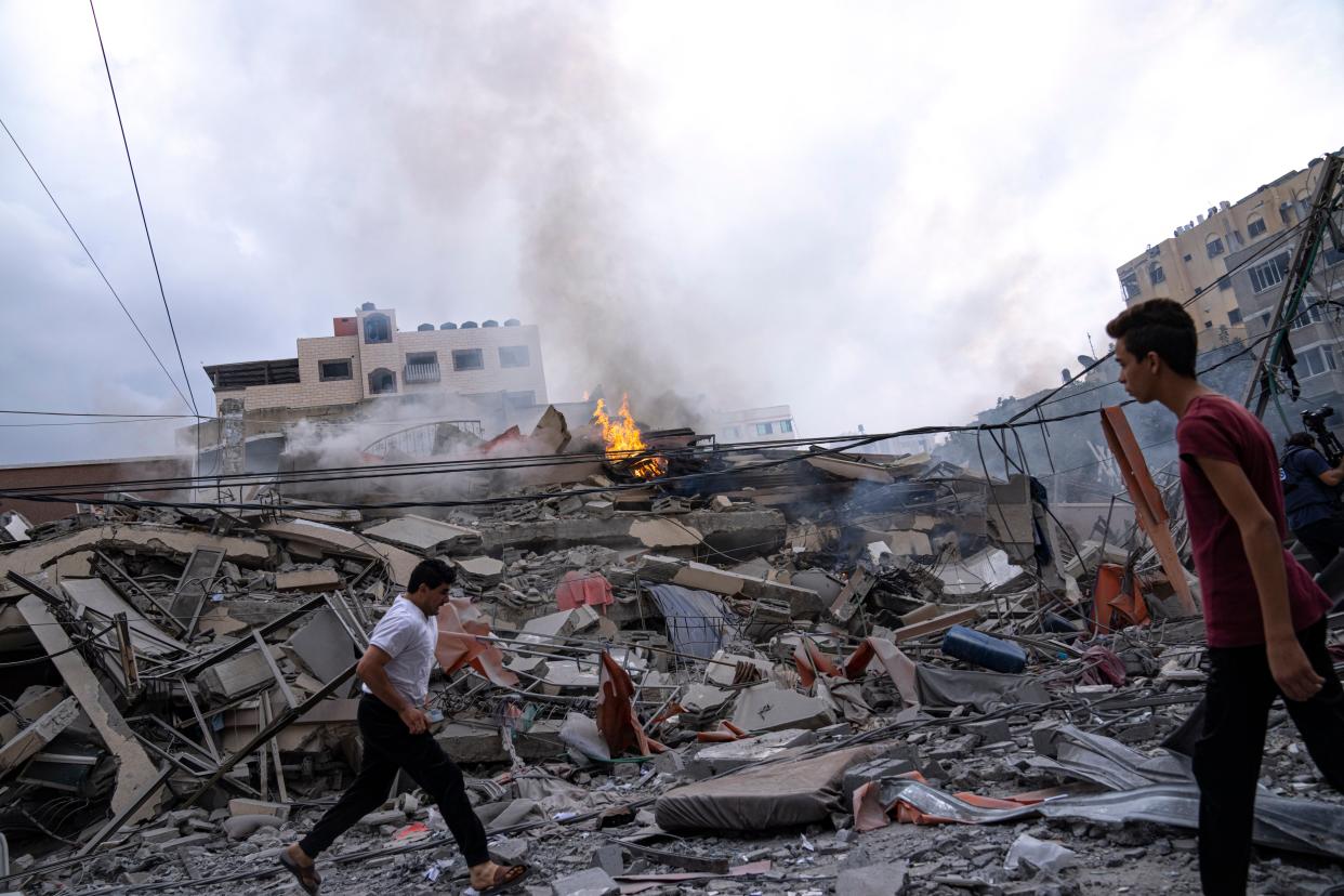 Palestinians walk amid the rubble following Israeli airstrikes that razed swaths of a neighborhood in Gaza City onTuesday (AP)