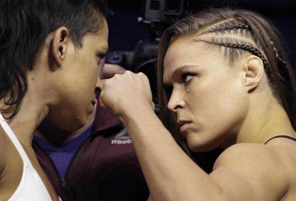 Ronda Rousey, right, and Amanda Nunes face off for photographers during an event for UFC 207, Thursday, Dec. 29, 2016, in Las Vegas. Rousey is scheduled to fight Nunes in a mixed martial arts women's bantamweight championship bout Saturday in Las Vegas. (AP Photo/John Locher)