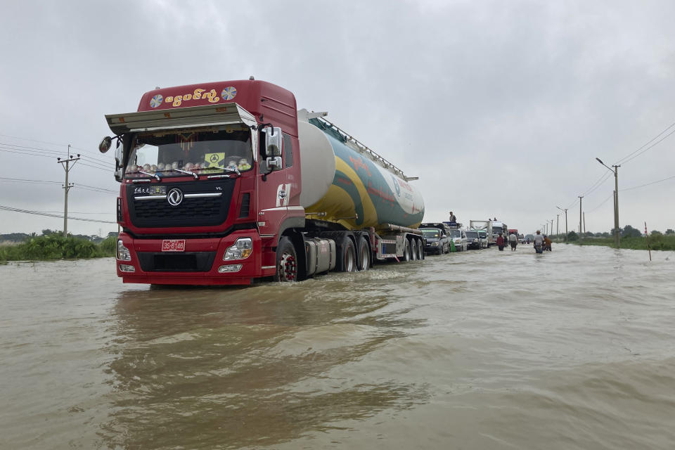 Vehicles drive along a flooded road in Bago, about 80 kilometers (50 miles) northeast of Yangon, Myanmar, Monday, Oct. 9, 2023. Flooding triggered by heavy monsoon rains in Myanmar’s southern areas has displaced more than 10,000 people and disrupted traffic on the rail lines that connect the country’s biggest cities, officials and state-run media said Monday. (AP Photo/Thein Zaw)