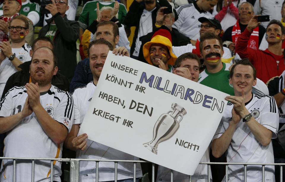 German fans hold a poster reading 'You can have our billions but you won't get the trophy' after Germany won the Euro 2012 soccer championship quarterfinal match between Germany and Greece in Gdansk, Poland, Friday, June 22, 2012. (AP Photo/Michael Sohn)