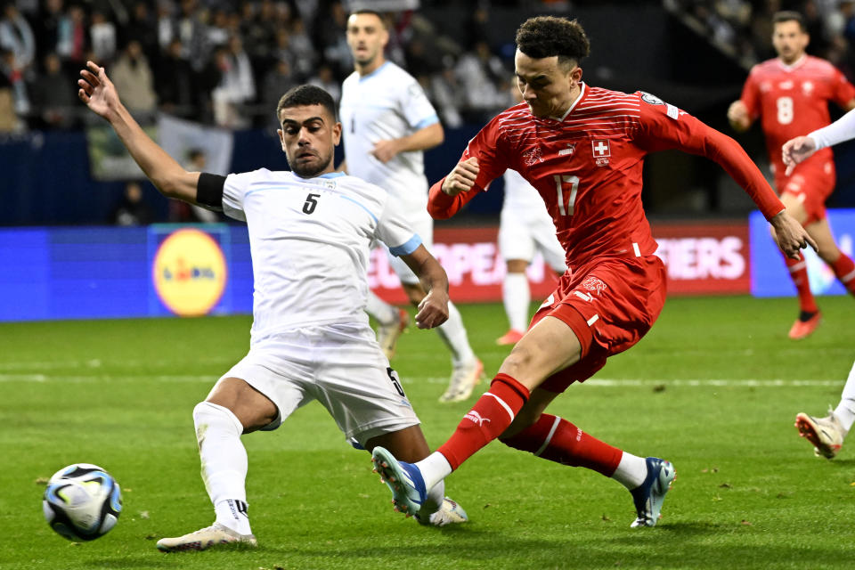 Israel's Raz Shlomo, left, tries to block Switzerland's Ruben Vargas during the Euro 2024 group I qualifying soccer match between Israel and Switzerland at the Pancho Arena in Felcsut, Hungary, Wednesday, Nov. 15, 2023. (AP Photo/Denes Erdos)