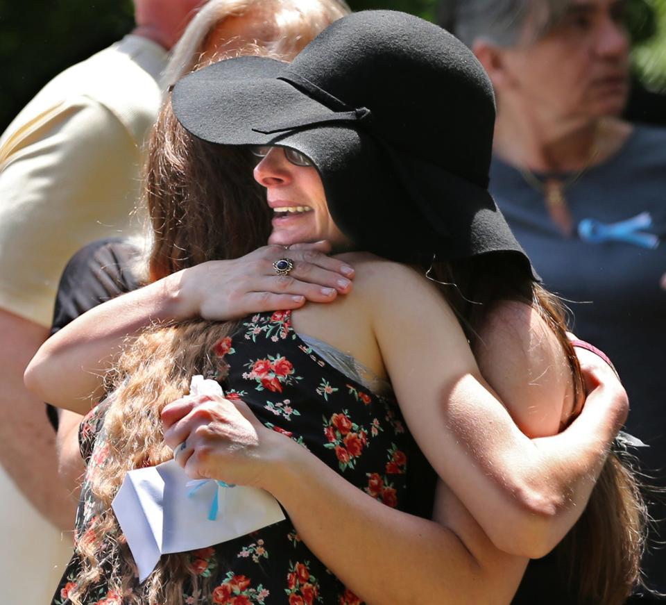 Kristina Foster, Curtis Cole's life partner of 24 years, gets an embrace of support during his funeral at Cold Springs Cemetery in East Rochester Sunday, June 12, 2022.