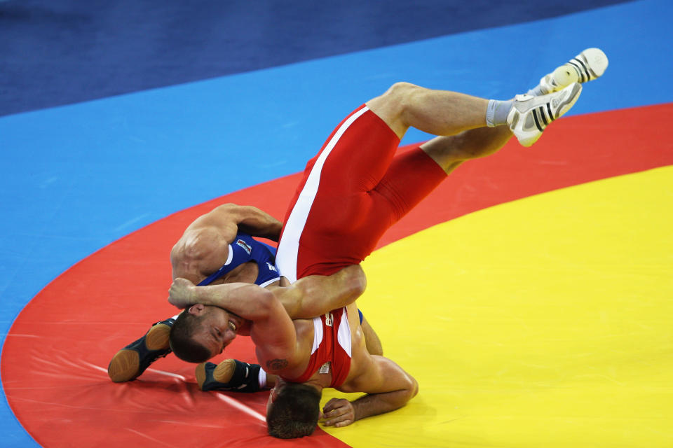 BEIJING - AUGUST 14: Mirko Englich (red) of Germany is thrown by Elis Guri (blue) of Albania in the Men's Greco-Roman 96kg quarter final bout at the China Agriculture University Gymnasium during Day 6 of the Beijing 2008 Olympic Games on August 14, 2008 in Beijing, China. (Photo by Ezra Shaw/Getty Images)