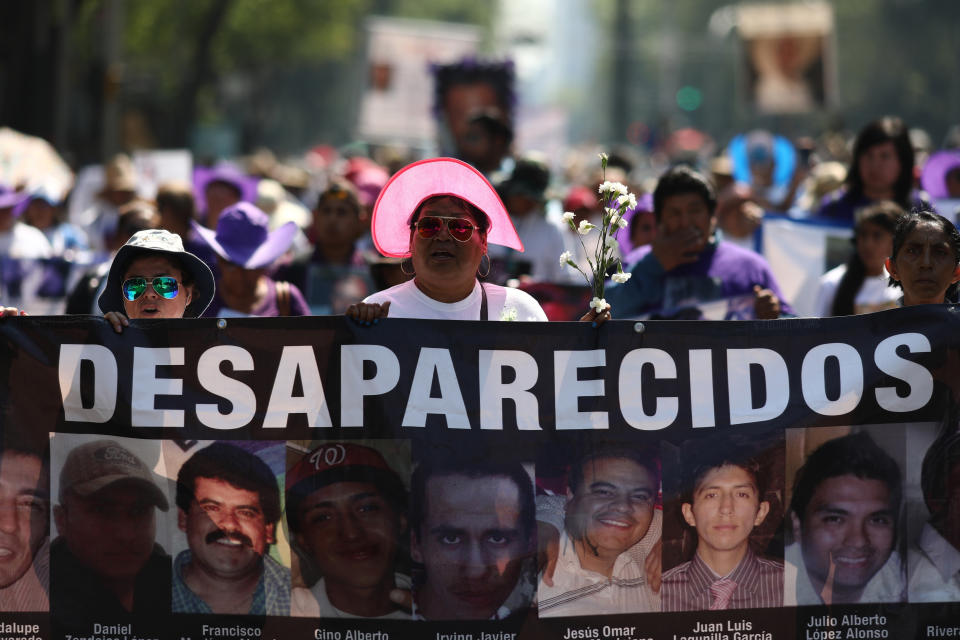People carry images of people who were disappeared, during a Mother's Day march in Mexico City, Friday, May 10, 2019. Mothers and other relatives of persons gone missing in the fight against drug cartels and organized crime are demanding that authorities locate their loved ones. (AP Photo/Eduardo Verdugo)