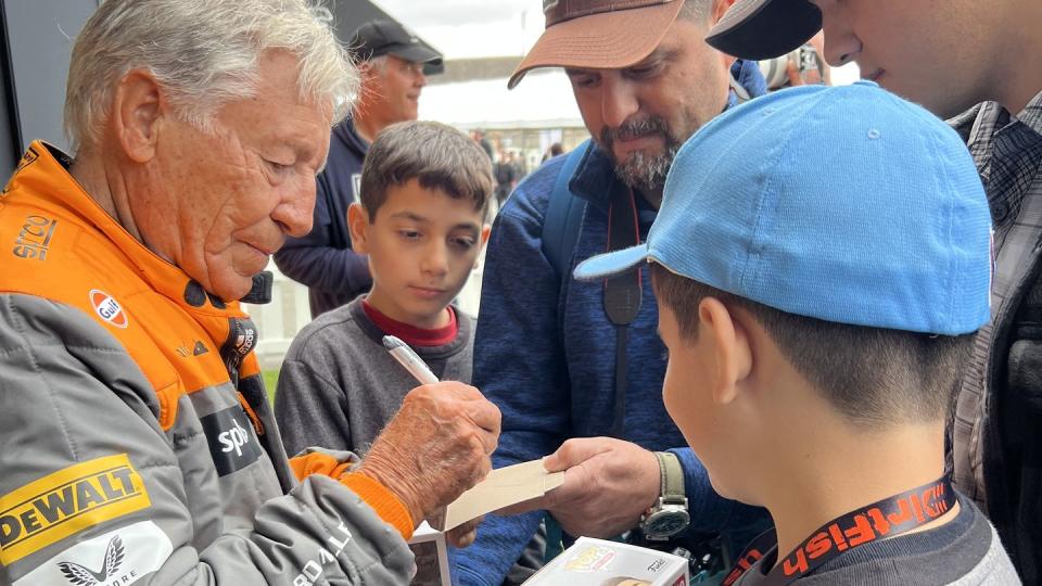 a man handing a boy a piece of paper